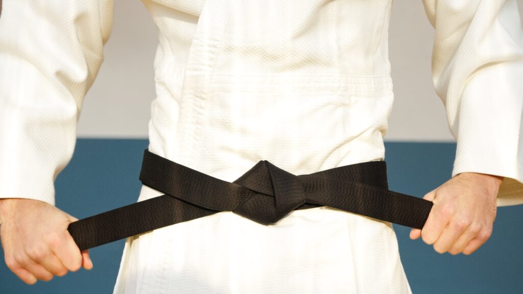 close up shot of a person holding a black belt